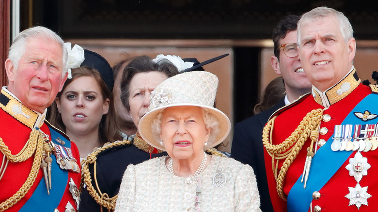 Prince Charles, the Queen, and Prince Andrew looking at something