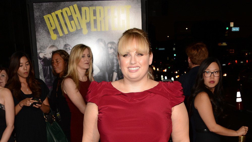 Rebel Wilson smiling with bangs and red dress