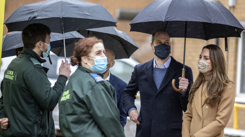 Prince William and Kate Middleton sharing umbrella in the rain