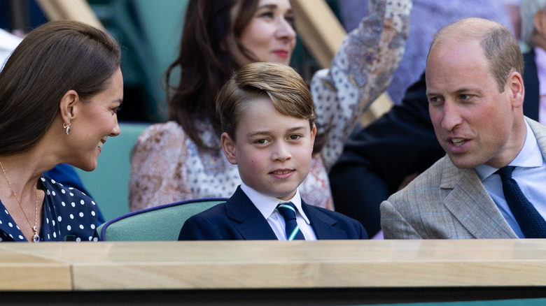 Catherine Middleton and Prince William smiling and talking to Prince George 