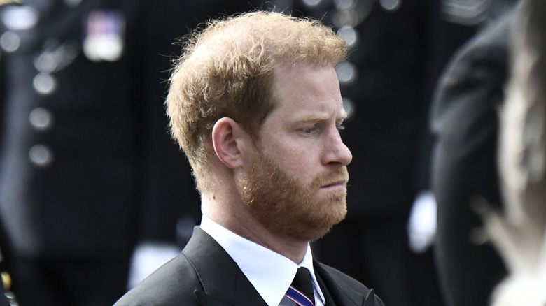 Prince Harry looks down during the queen's procession