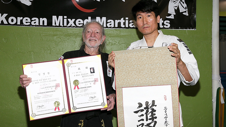 Willie Nelson receiving his 5th degree black belt award from Grand Master Sam Um