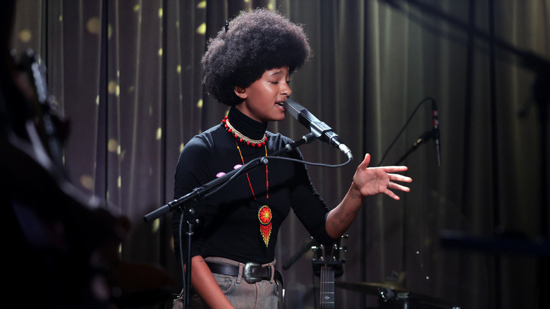 Willow Smith singing into microphone with band