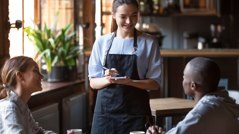 Couple at restaurant talking to waitress