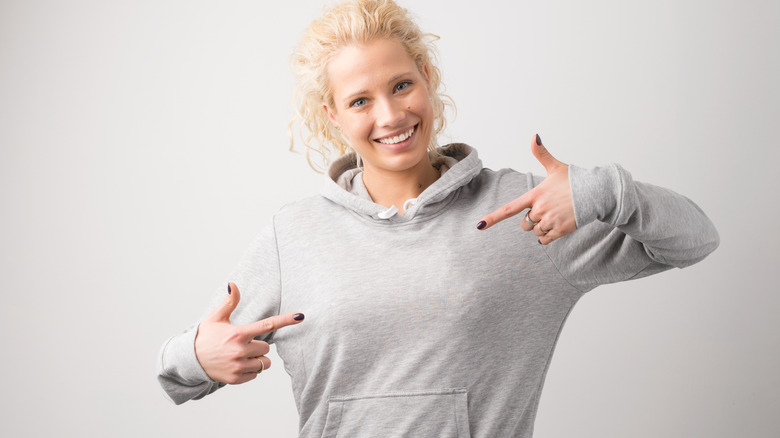 woman pointing to sweatshirt hoodie