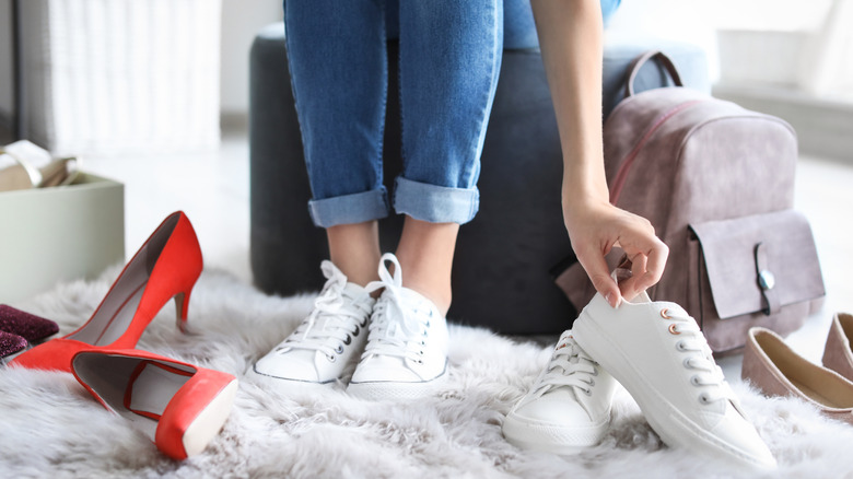 woman trying on different pairs of shoes