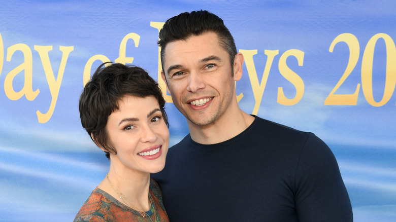 Paul Telfer and co-star Linsey Godfrey smile for the camera. 