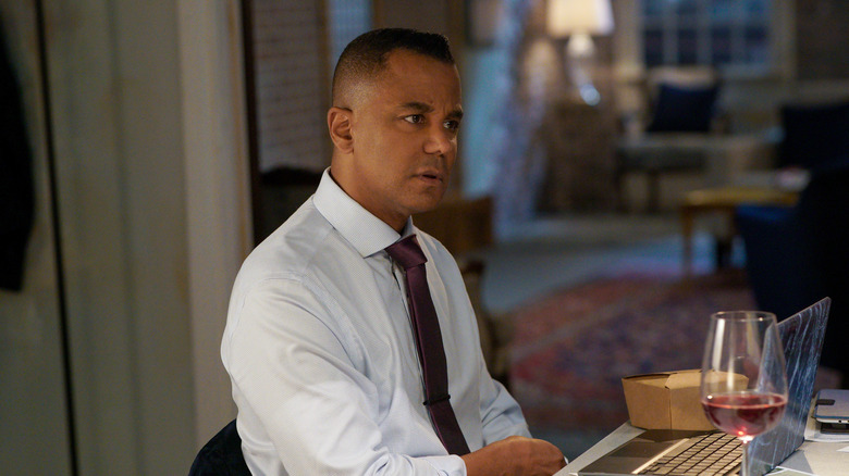 Yanic Truesdale with a laptop and glass of wine