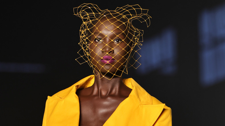 Model wearing a yellow suit and headpiece