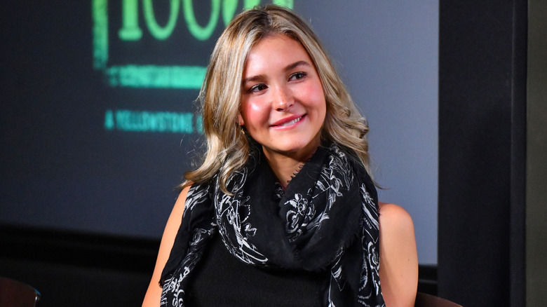 Isabel May smiling biting lip wearing scarf