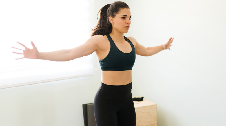 woman doing jumping jacks at home