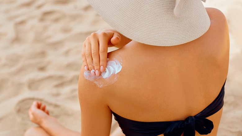 Woman applying sunscreen to shoulders