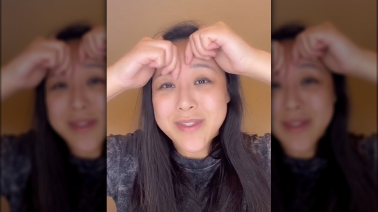 woman massaging third eye in TikTok video