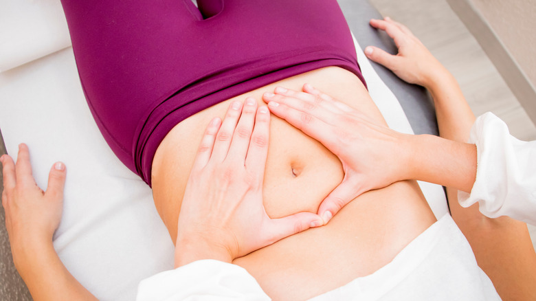 Doctor examining woman's stomach