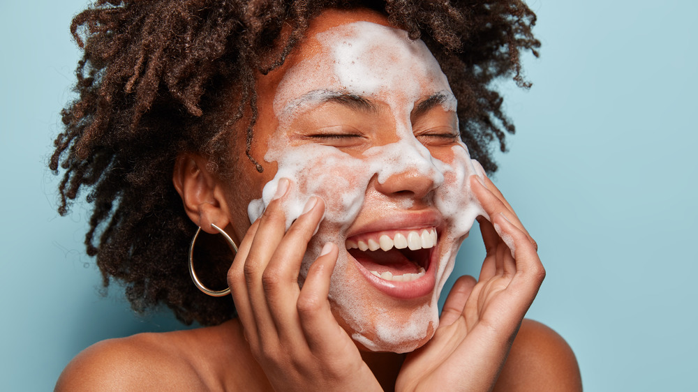 Woman cleaning skin with foaming cleanser