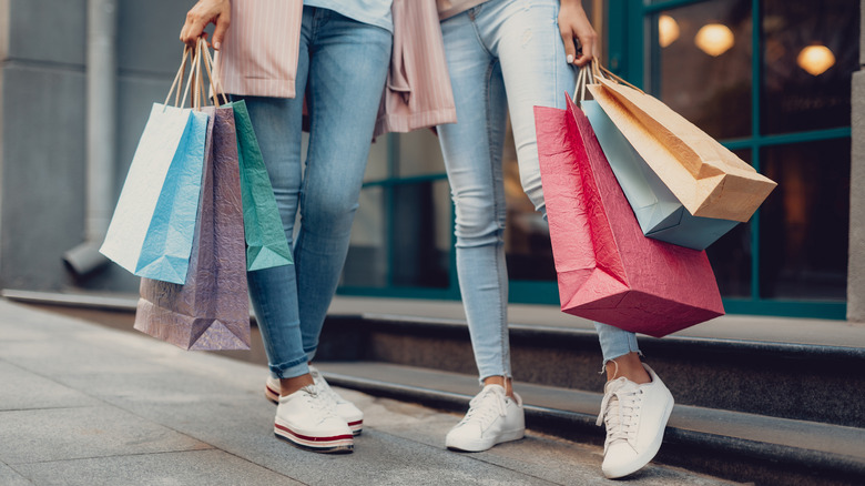 Two women wear skinny jeans while shopping
