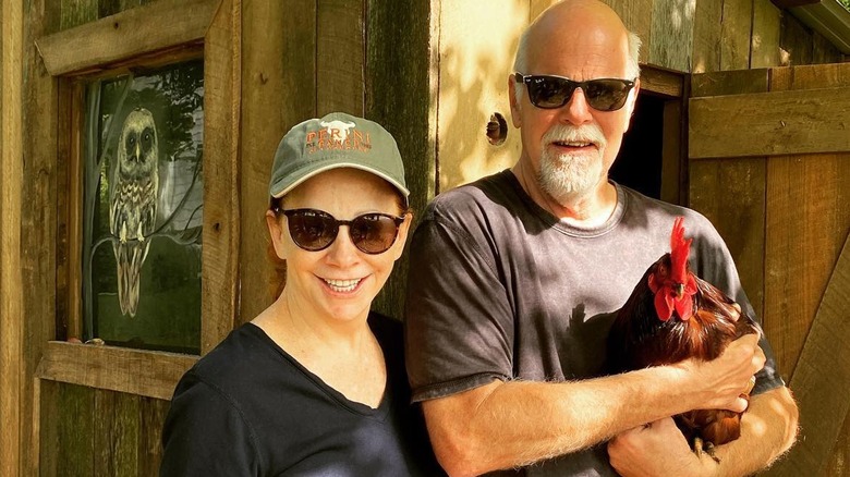 Reba McEntire smiling with man, chicken