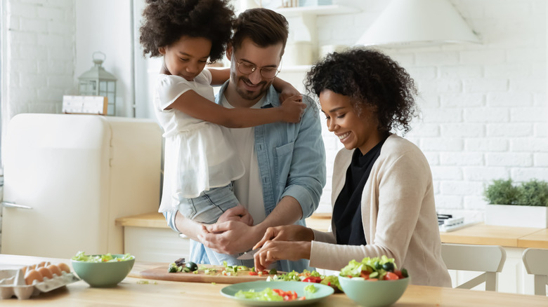 Family making salad in kitchen