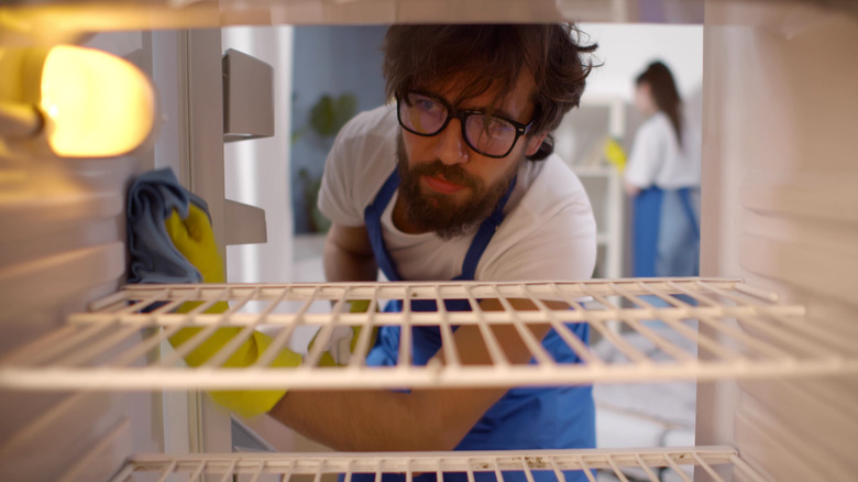 man cleaning fridge