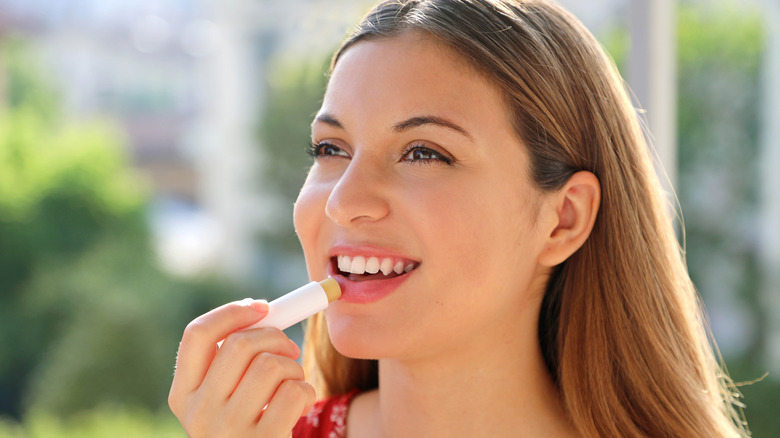 Woman applying lip balm