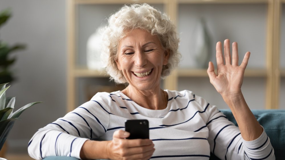 Older woman laughing at something on phone