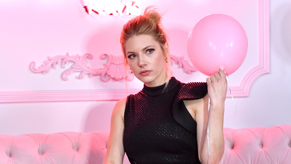 Katheryn Winnick holding a pink balloon in a pink room