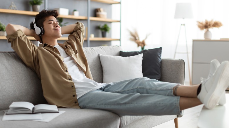 Man relaxing on couch listening to headphones