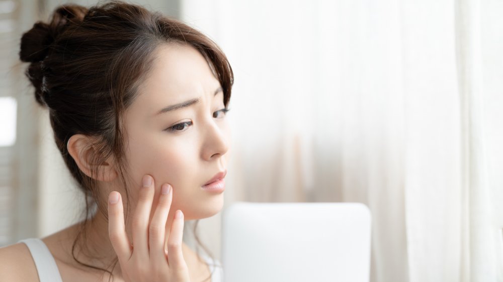 Woman checking her skin for a reaction