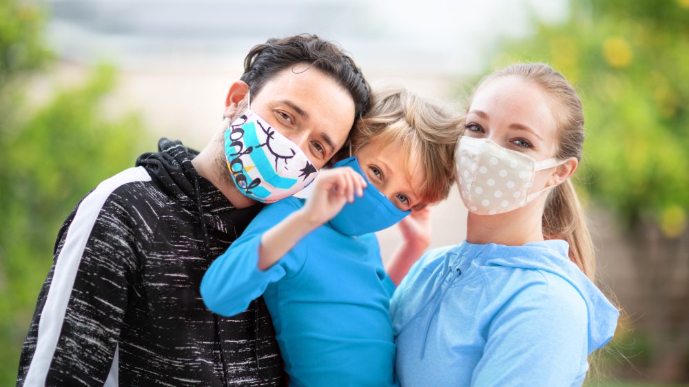 family smiling with face masks on