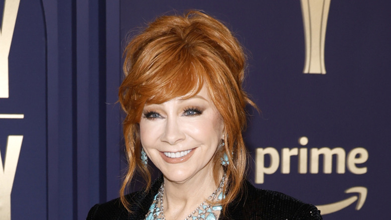 Reba McEntire smiling dark blue background