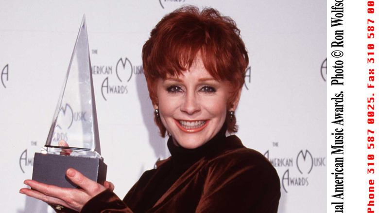 Reba McEntire holding up award