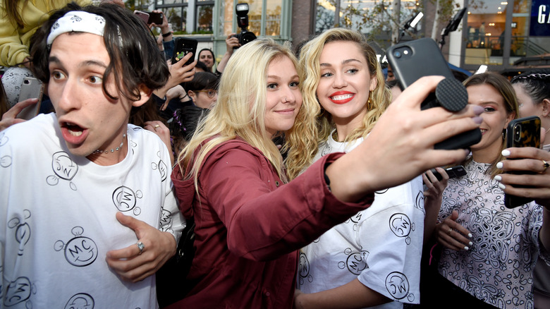 Miley Cyrus taking selfies with fans