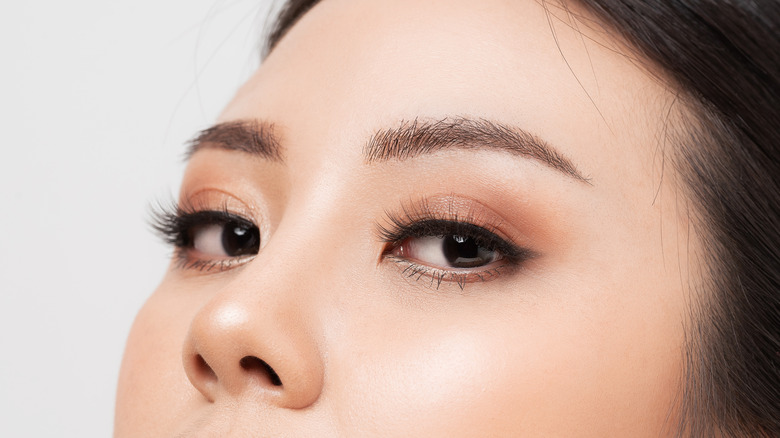 Closeup woman with bold eyeliner and long false lashes