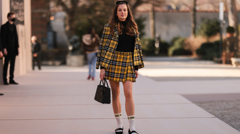 Model wearing yellow and black plaid suit