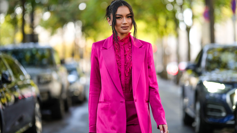 Model wearing hot pink blazer and ruffle blouse