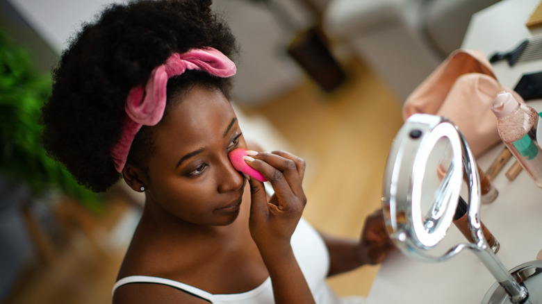 Woman blending concealer in