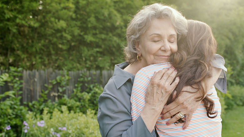 Two women hugging in a garden