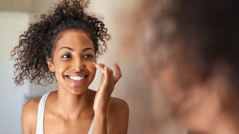 Woman applying moisturizer