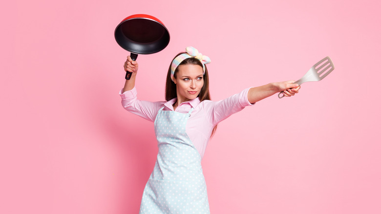 Woman holding spatula and pan