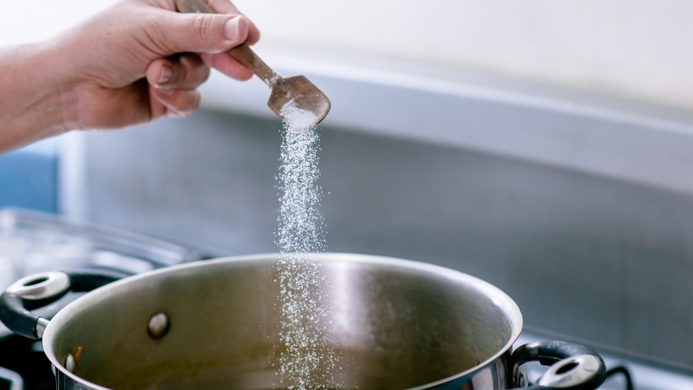 adding salt to water for cooking