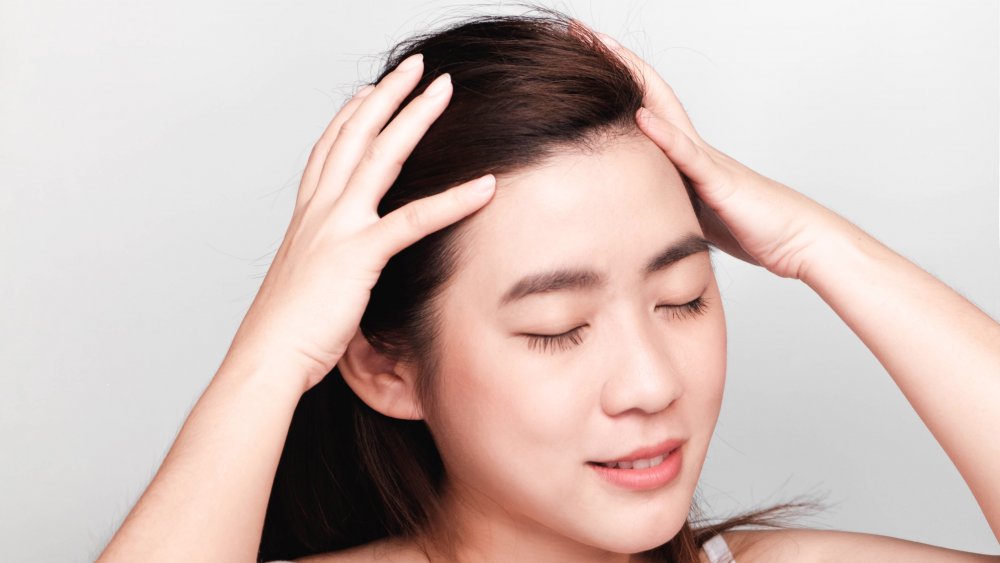 Woman giving herself scalp massage 