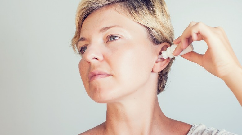 Woman applying ear drops