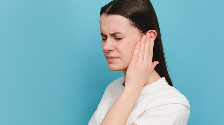 Woman holding ear in pain