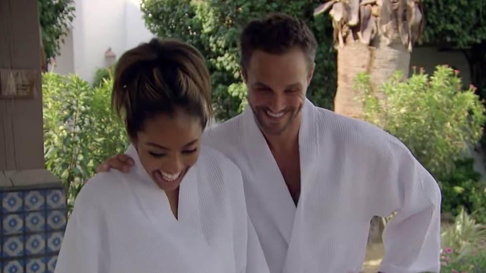 Zac and Tayshia smiling in robes during filming