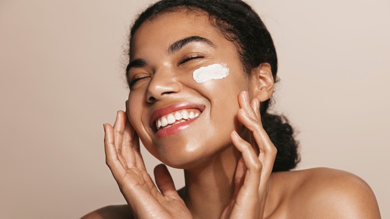 woman with moisturizer on cheek 