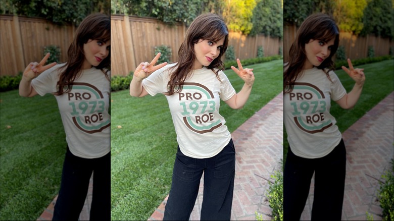 Zooey Deschanel making peace signs in a "Pro Roe" t-shirt