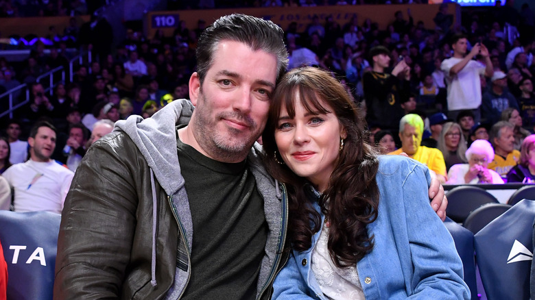 Jonathan Scott sitting with Zooey Deschanel in arena